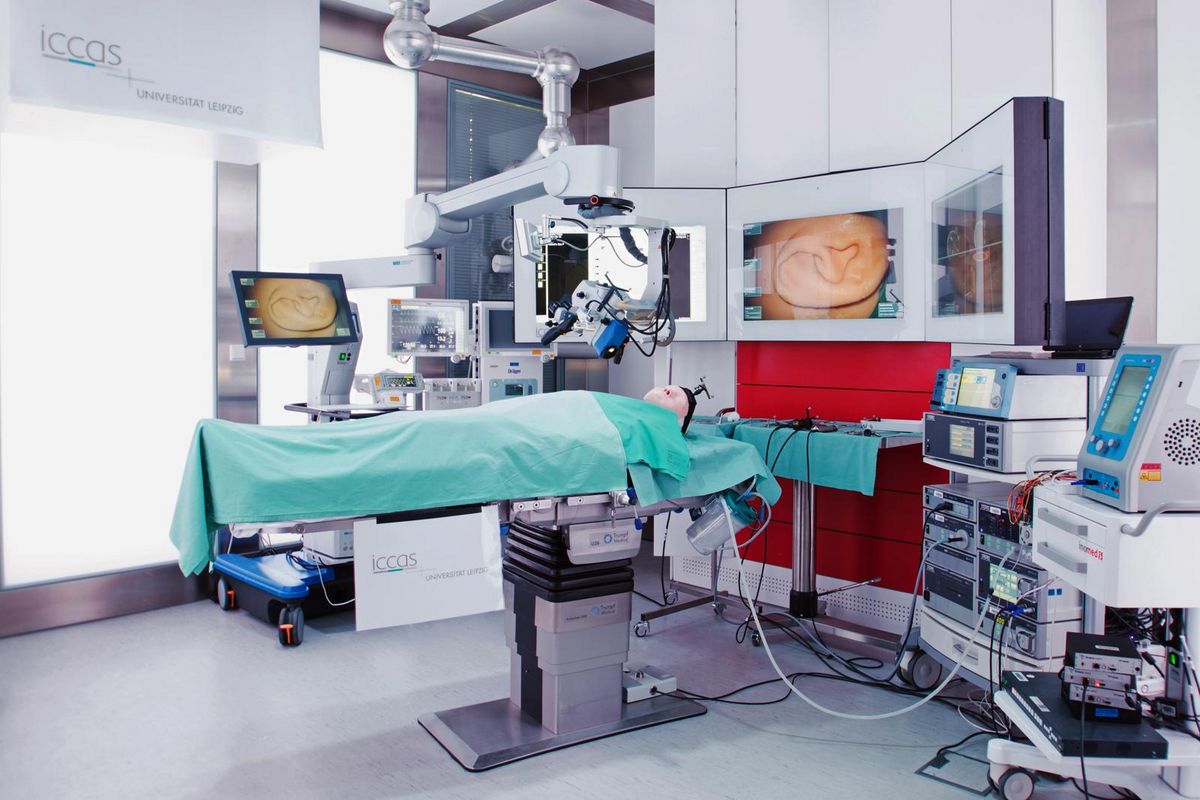 zur Vergrößerungsansicht des Bildes: Farbfoto eines Operationssaales mit verschiedenen technischen Geräten und einem Dummy-Menschen auf einer Liege